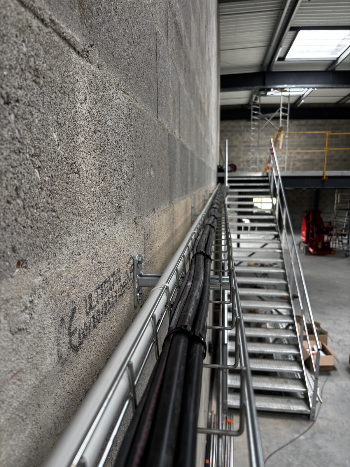 Chemin de cables electriques pose le long d'un mur technique